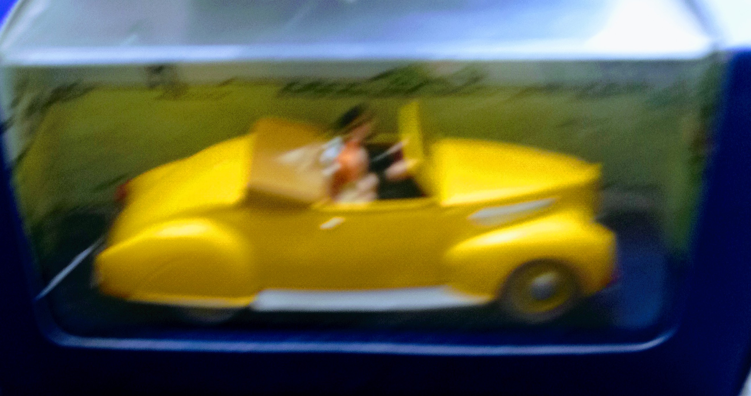 Speeding toy yellow sportscar