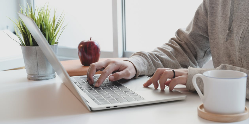 Sat at a laptop stock image - Attract clients to your freelancing business